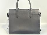 a grey leather handbag sitting on top of a white surface