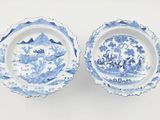 pair of blue and white dishes with a mountain scene in the middle