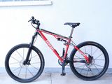 un vélo rouge et noir garé contre un mur blanc