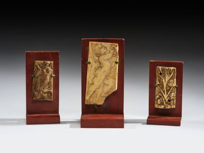 trois plaques en bois ornées de reliefs représentant une femme et un homme