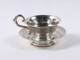 silver plated tea cup with saucer and saucer on a saucer