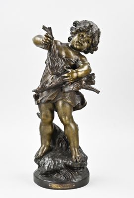 une statue en bronze représentant un garçon tenant un oiseau sur un rocher