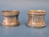 pair of antique silverplated napkin holders on a blue background