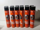 six bombes aérosols orange de nettoyant pour freins posées sur une surface blanche
