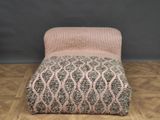 une chaise rose et grise posée sur un parquet
