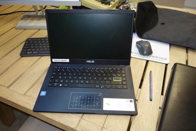 a laptop computer sitting on a wooden desk next to a keyboard and mouse