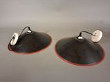 pair of black and white lamps with orange trims on a gray surface