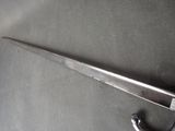 a large knife that is laying on a table