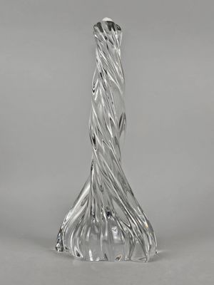un vase en verre transparent posé sur une table près d'un mur blanc