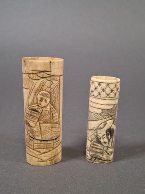 two old carved wooden cylinder holders sitting on top of a table