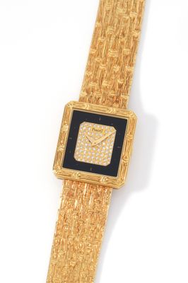 a close up of a gold wrist watch with a black face