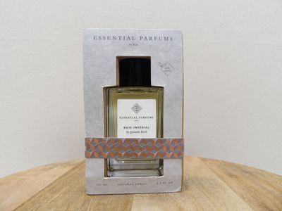 une photo d'un flacon de parfum posé sur une table en bois