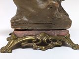 a bronze statue of a man with a hat on top of a table
