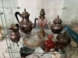 a glass display case with a variety of antique items on it