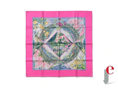 L'écharpe carrée rose est ornée d'un motif représentant un oiseau et des fleurs.