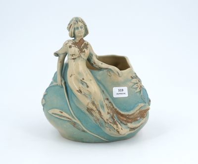 a blue vase with a woman sitting on it