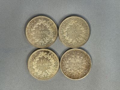quatre types différents de pièces d'or sur une surface grise