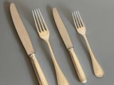 un service composé de quatre fourchettes et d'un couteau posé sur une table