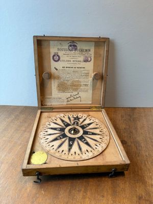 a wooden box with a compass on it on a table