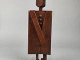 an old wooden sculpture of a man in a tuxedo