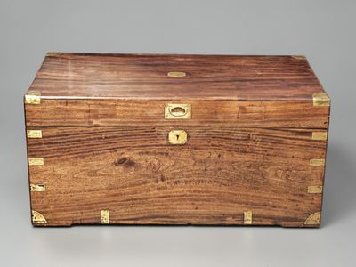 une boîte ancienne en bois, ornée de ferrures en laiton sur les côtés