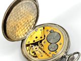 a pocket watch that is open on a white surface
