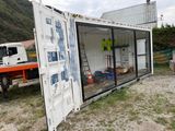 un grand conteneur blanc posé au milieu d'un champ