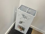 a trash can that is sitting in the corner of a room