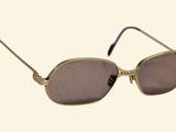 sunglasses on a white background with a brown lens and a gold frame