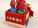 a red toy truck with a bunch of toys in it
