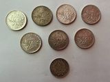 six pièces de monnaie britanniques différentes posées sur une surface blanche