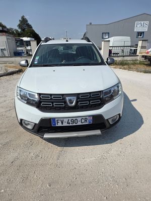 l'avant d'une Dacia blanche garée sur un parking