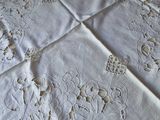 a table with a white table cloth with a bunch of embroidered flowers on it
