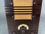 an old fashioned radio sitting on top of a table next to a clock