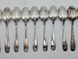 six silver spoons are lined up in a row on a table