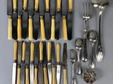 a lot of silver and yellow knives and spoons