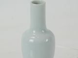 a small white vase sitting on a clear surface