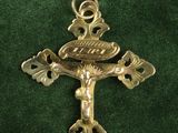 gold cross with a bird on it on a green cloth