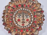 une image représentant un visage de soleil, sculpté dans du bois