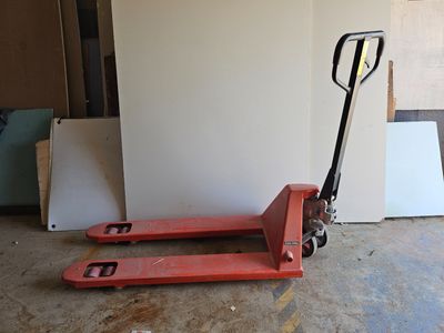 un chariot élévateur rouge garé au milieu d'une pièce