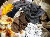 a pile of clothes that is on a bed