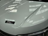 a close up of a white car with a sticker on it ' s hood