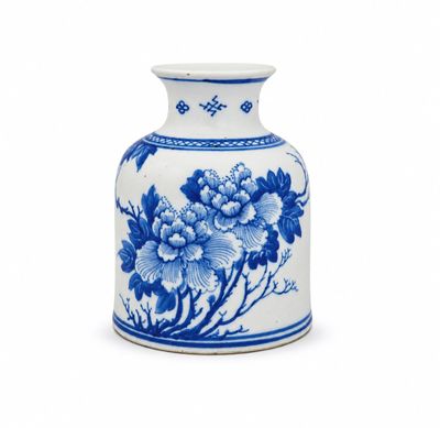 un vase bleu et blanc posé sur une surface blanche