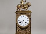 une horloge en or surmontée d'une statue représentant un homme à cheval