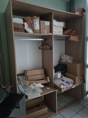 un placard sur lequel sont posés de nombreux cartons et vêtements