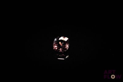 un gros plan d'une bague dans l'obscurité, sur fond noir