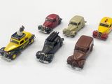 plusieurs petites voitures sont alignées sur une surface blanche