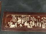 two pieces of wood with carvings on them sitting next to each other