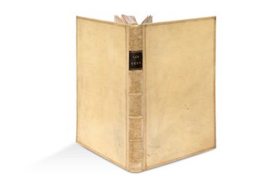 un vieux livre à la couverture dorée posé sur une surface blanche