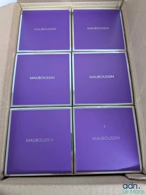 Six boîtes de Mauroussin se trouvent dans un carton posé sur une table